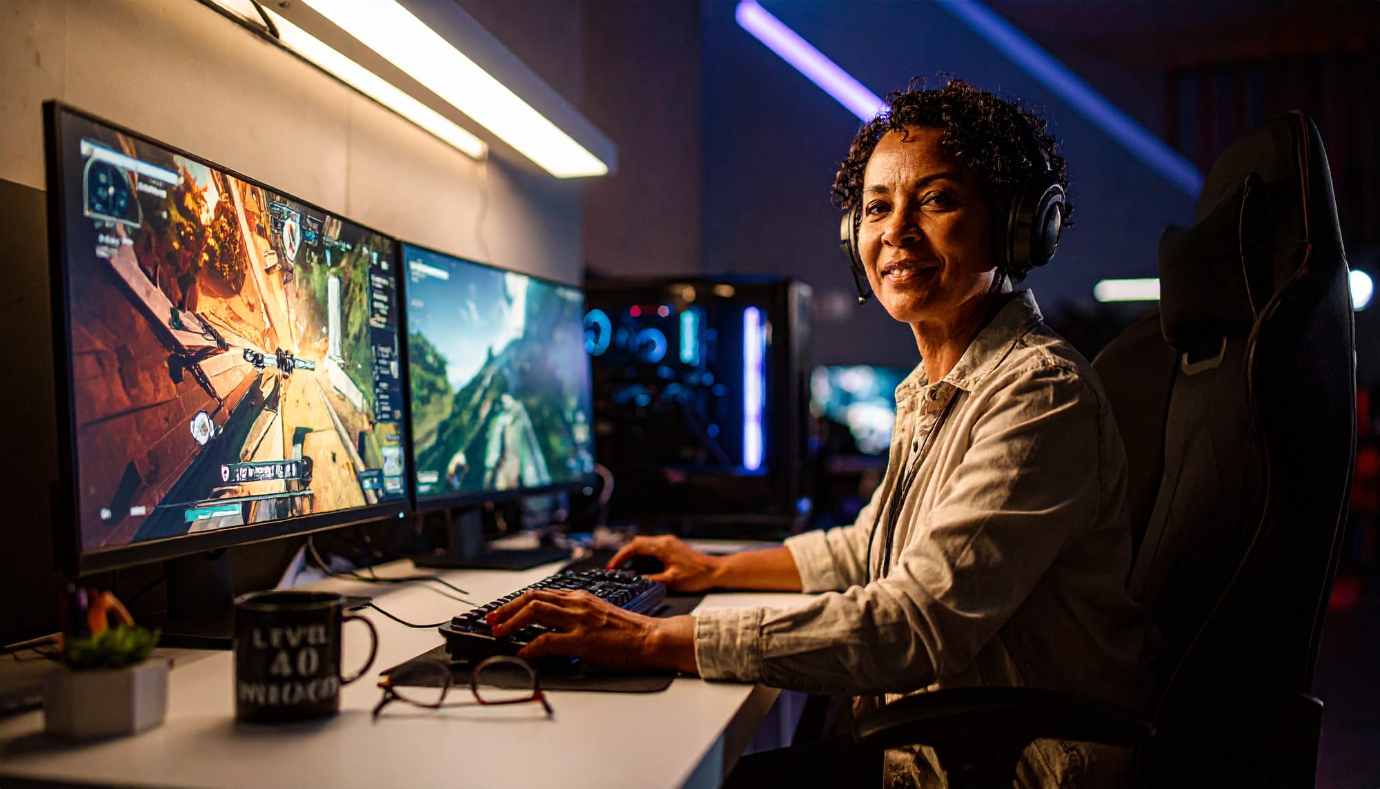 Smiling female gamer in her 40s playing computer game with gaming headset