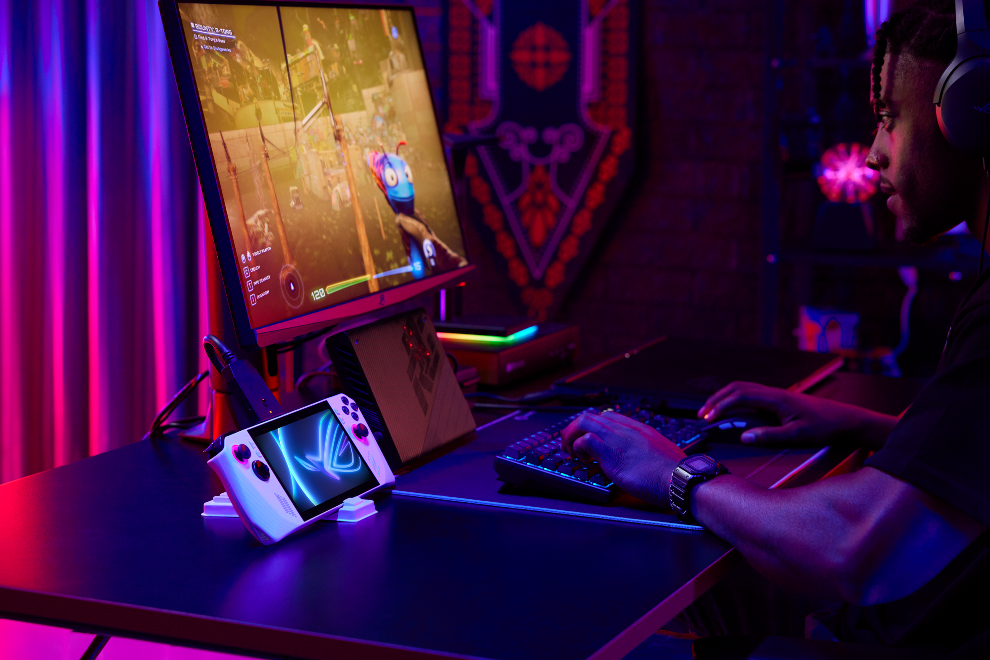 An Asus ROG Ally sitting on a desk. The handheld console is connected to a monitor. A gamer is playing games on it with a connected keyboard.