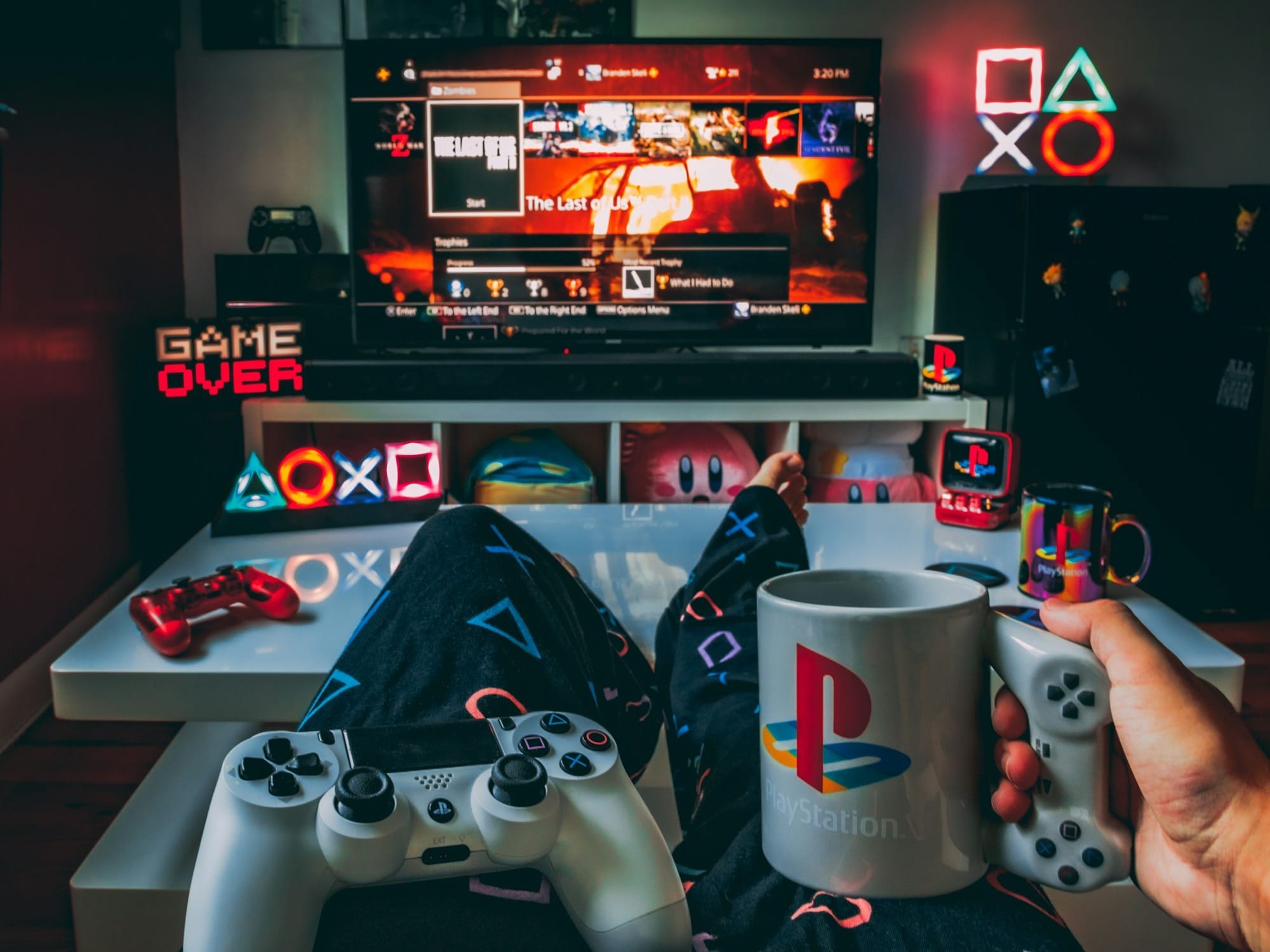 a person holding a cup and a game controller in front of a television